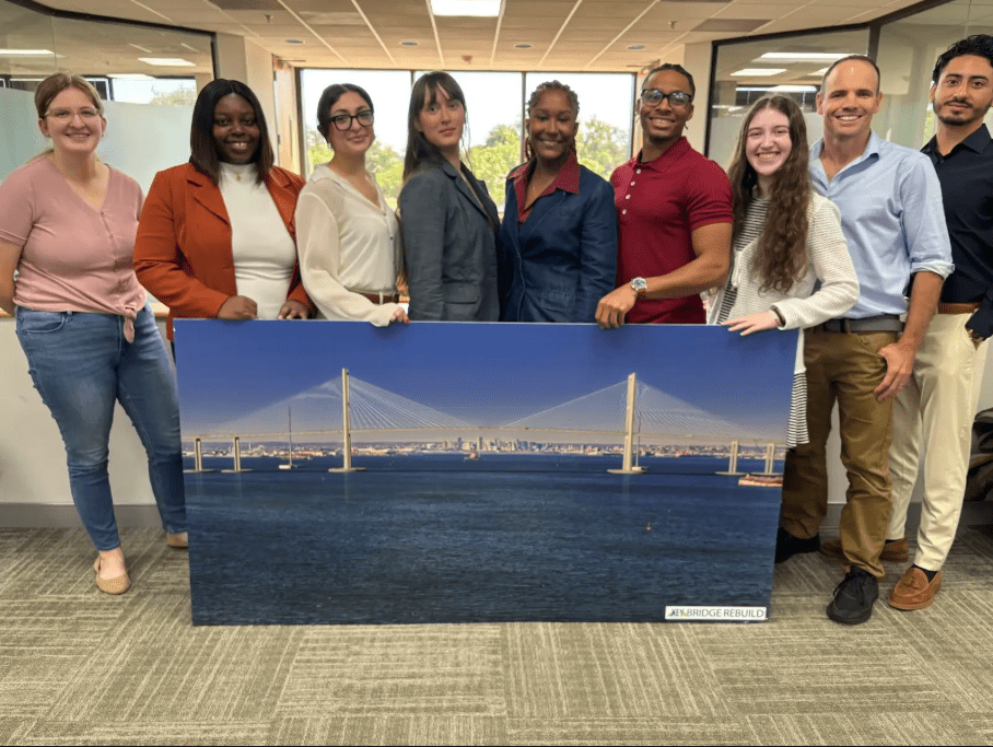 interns holding a large bridge rendering