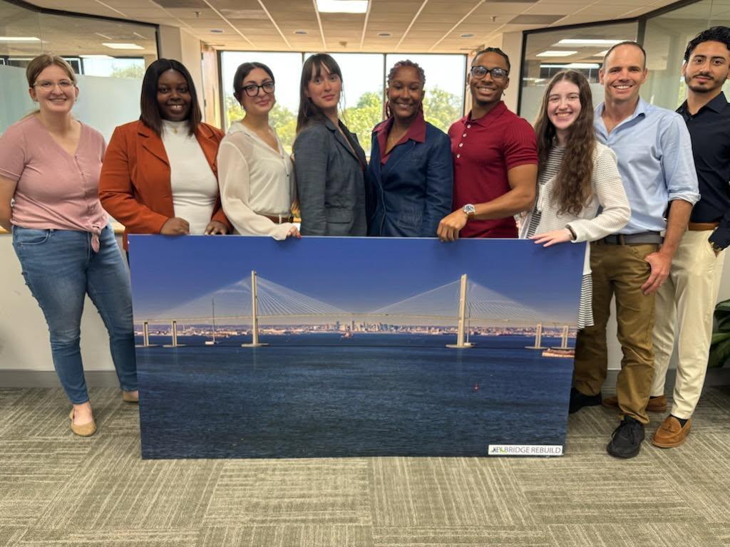Image of people holding a photo of a bridge rendering.