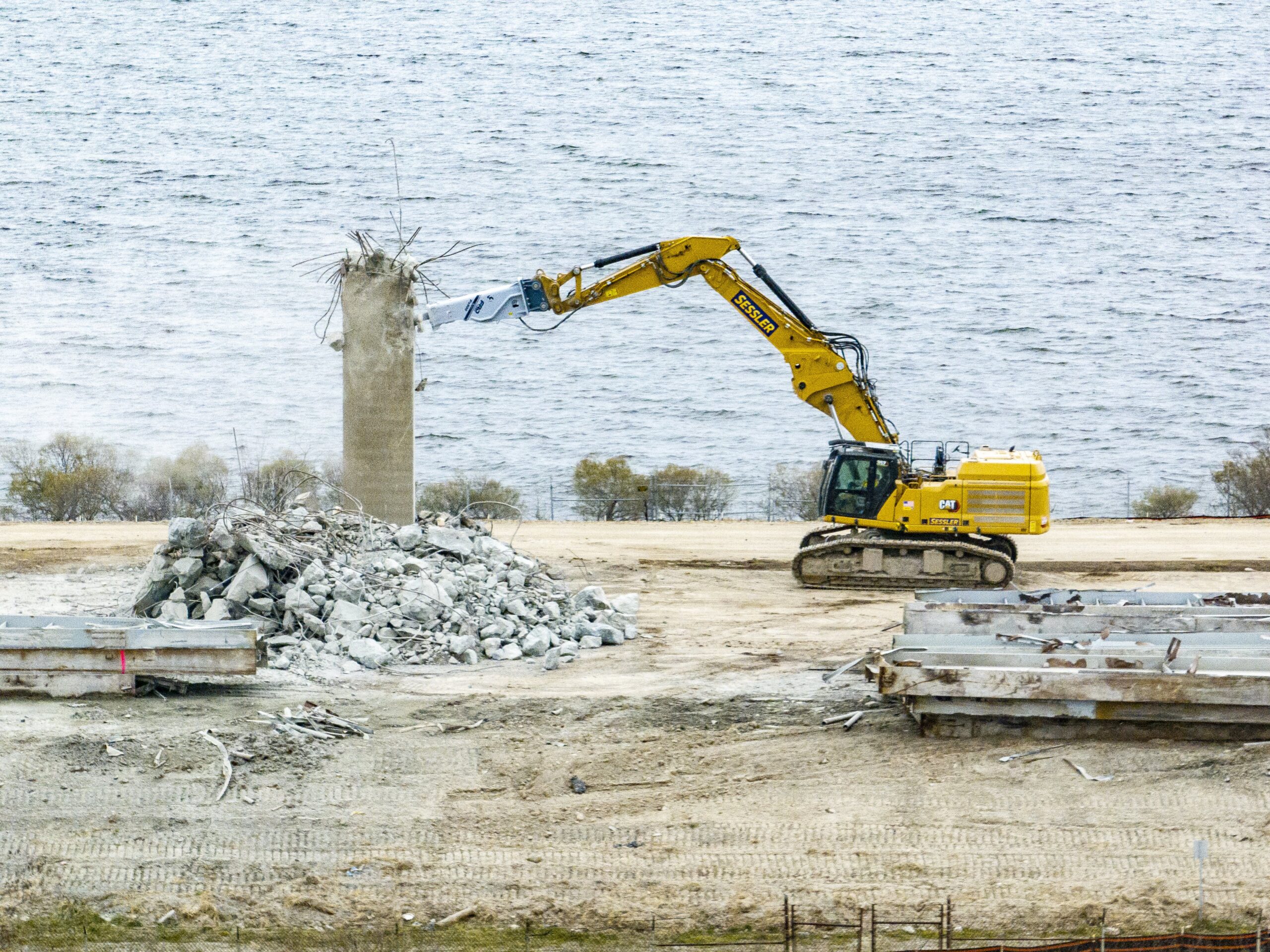 Aerial view of machine taking apart portion of a bridge.